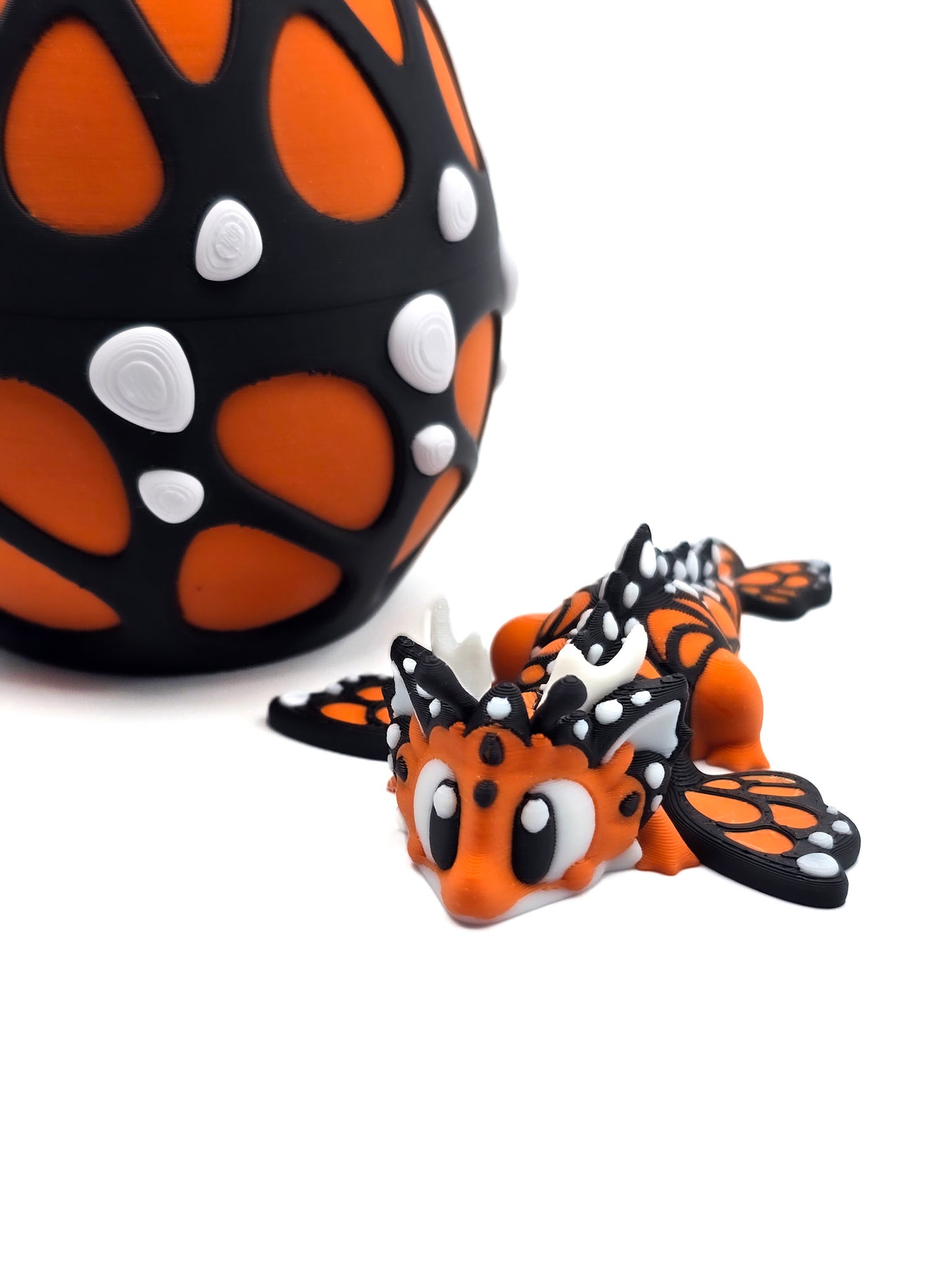 3D geprinte vlinder-draak in zwart-oranje ei – fantasy speelgoed en opbergdoosje