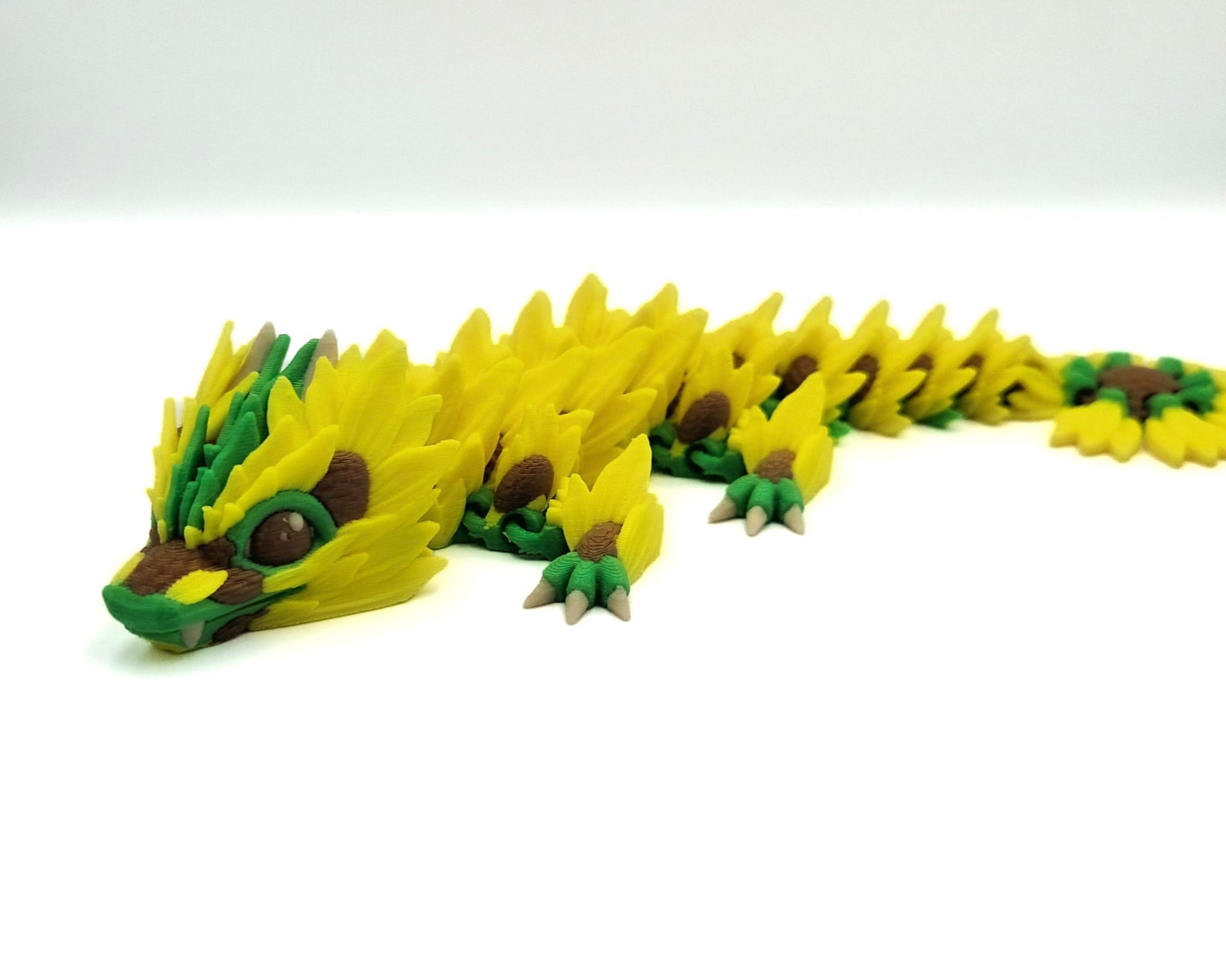 "3D printed sunflower flexi dragon," "flexible dragon toy," "sunflower dragon."